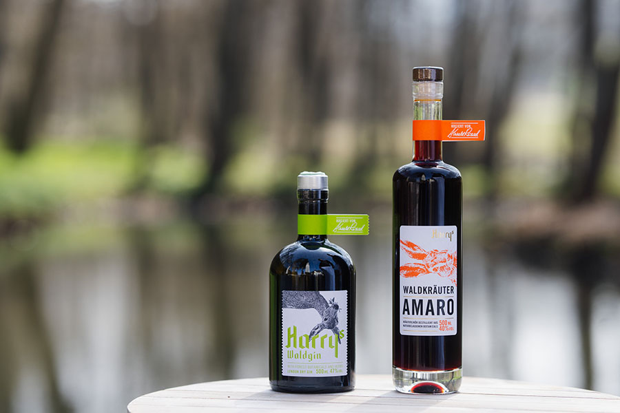 Harrys Waldgin und Harrys Waldkräuter Amaro fotografiet vor Landhaus